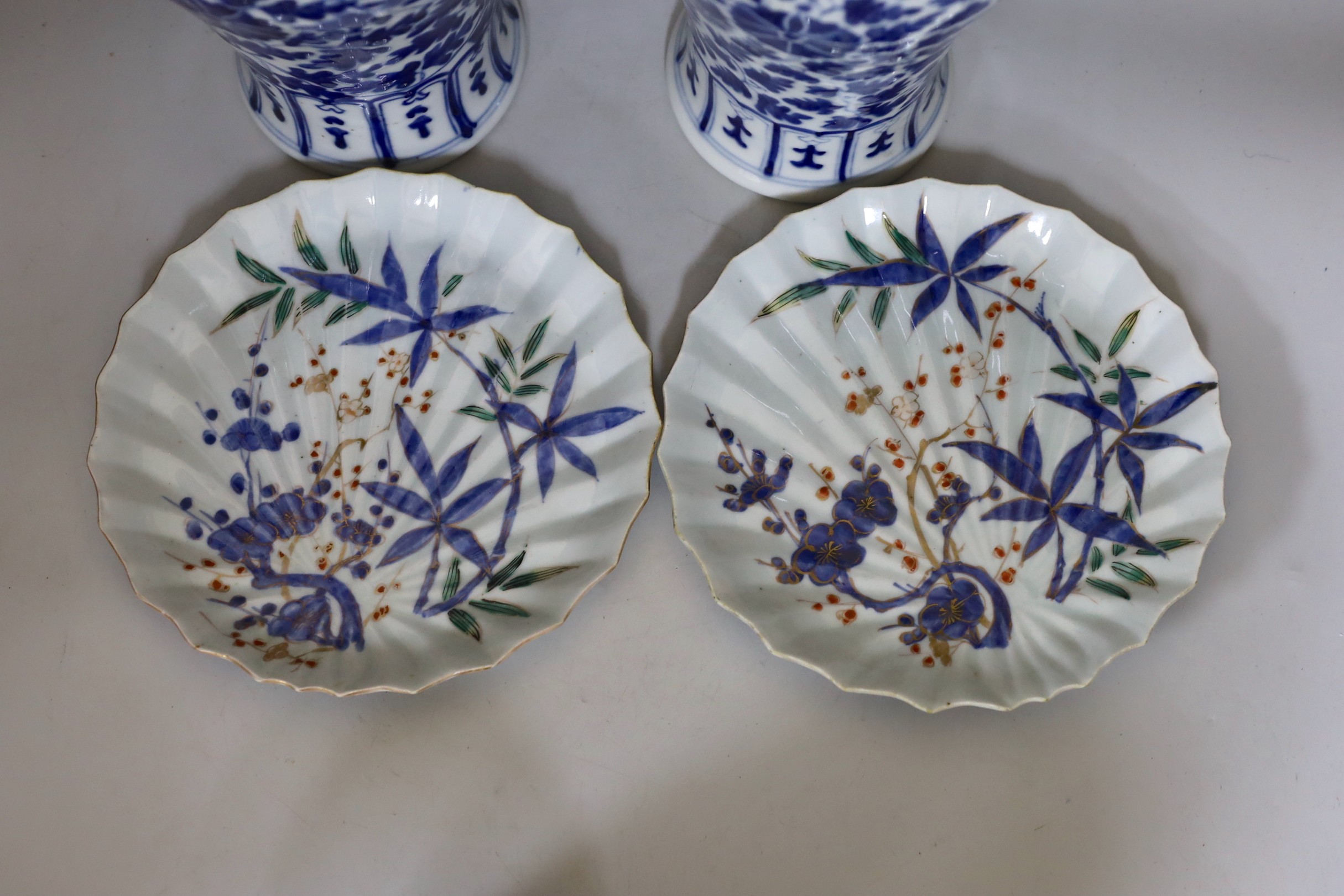 Two early 20th century Chinese blue and white vases with lion dog covers, together with a blue and white prunus jar and a pair of Japanese export flower dishes, and covers 33cm high